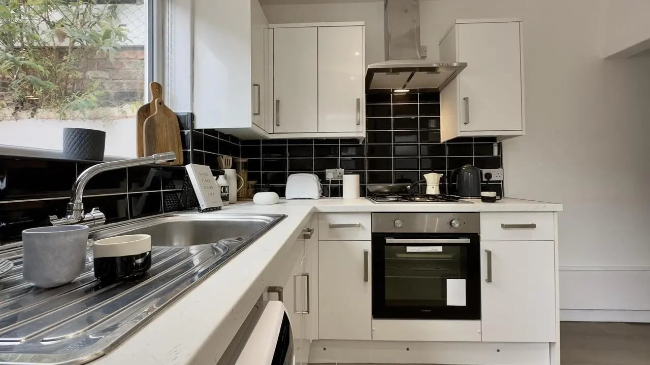 White cabinets black tile oven sink kitchen at 4 Bedroom House at 126, Empress Road in Liverpool Student Accommodation