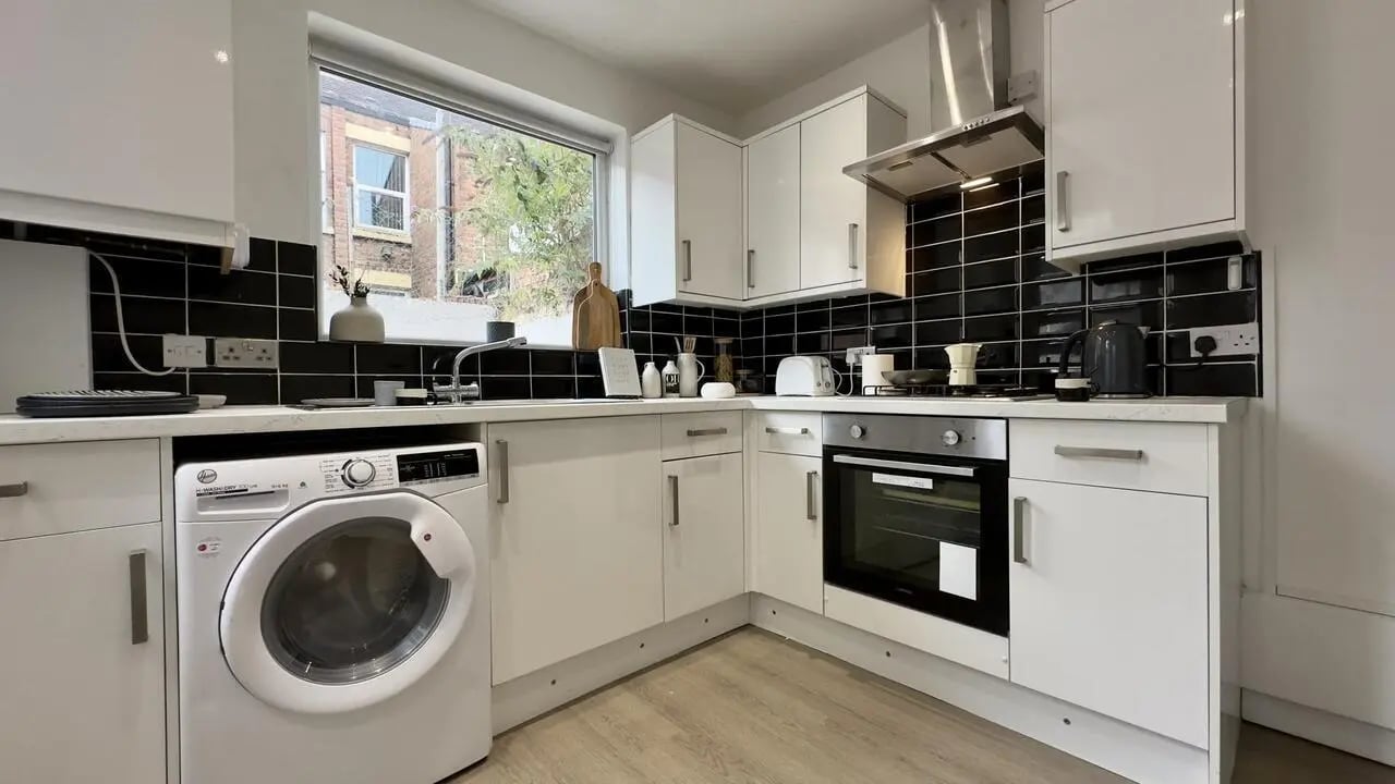 Modern kitchen with white cabinets appliances and black tiles kitchen at 4 Bedroom House at 126, Empress Road in Liverpool Student Accommodation