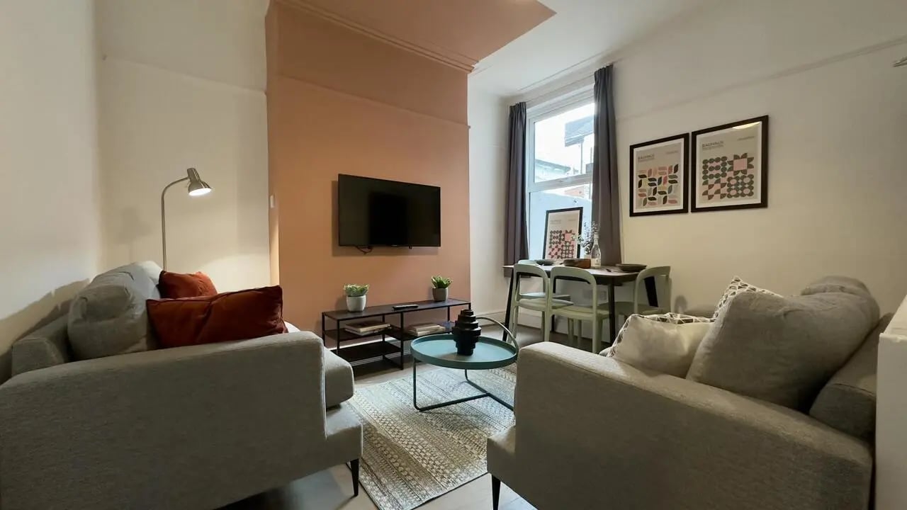 Two sofas television dining table and chairs living room at 4 Bedroom House at 126, Empress Road in Liverpool Student Accommodation