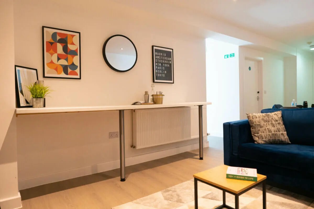 Modern desk with art and blue sofa Living room at 8 Bedroom House at 79, Crofton Street in Manchester Student Accommodation