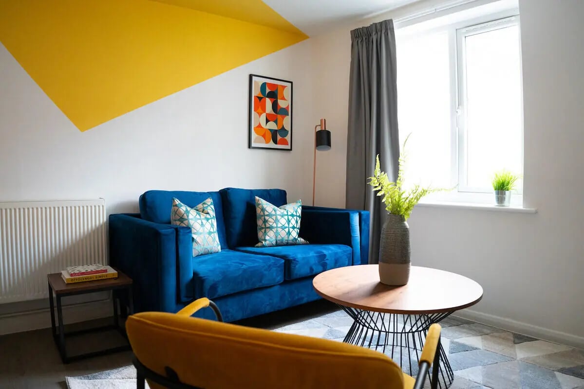 Blue sofa pillows art lamp side table living room at 6 Bedroom House at 64A, Monson Street in Lincoln Student Accommodation