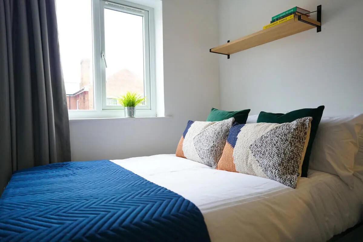 Bed with pillows and blue throw bedroom at 6 Bedroom House at 64A, Monson Street in Lincoln Student Accommodation
