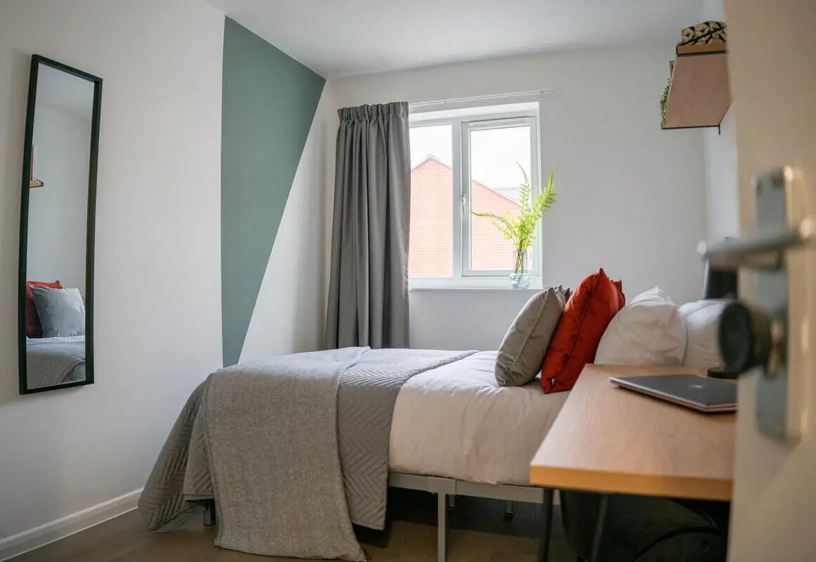 Bed with grey blanket pillows and mirror bedroom at 6 Bedroom House at 64A, Monson Street in Lincoln Student Accommodation