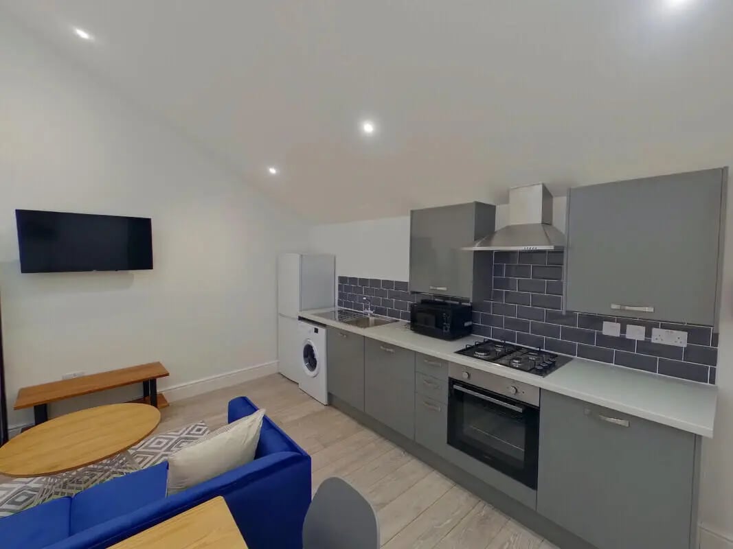 Sofa television wooden table kitchen counter oven kitchen at 2 Bedroom House at 20 G, Portland Street in Lincoln Student Accommodation
