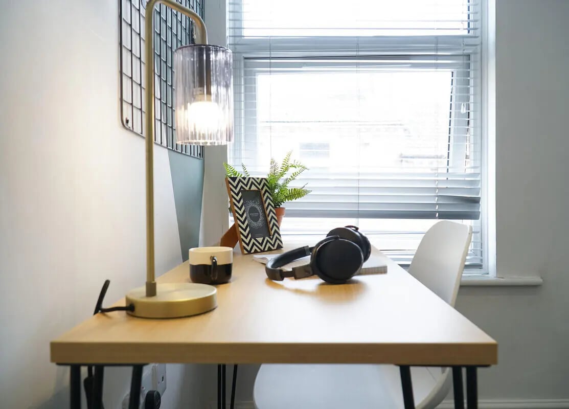 Desk with lamp headphones photo frame plant study area at 6 Bedroom House at 3, Baggholme Road in Lincoln Student Accommodation