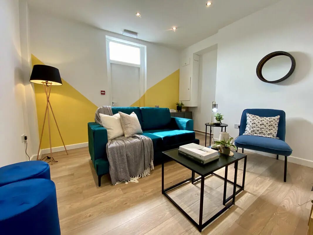 Teal sofa blue chair coffee table living room at 2 Bedroom House at Flat 2, 36, CARLTON AVENUE in Manchester Student Accommodation
