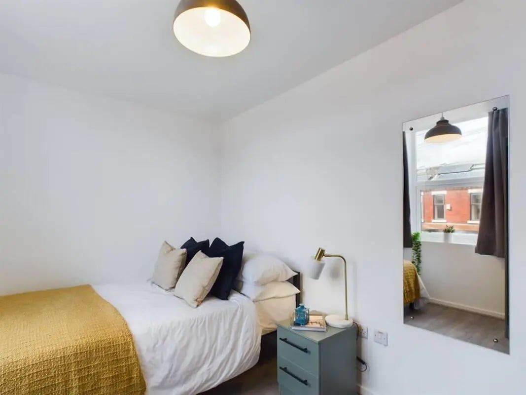 Bed with pillows and throw mirror reflection bedroom at 5 Bedroom House at 2, Crofton Street in Manchester Student Accommodation