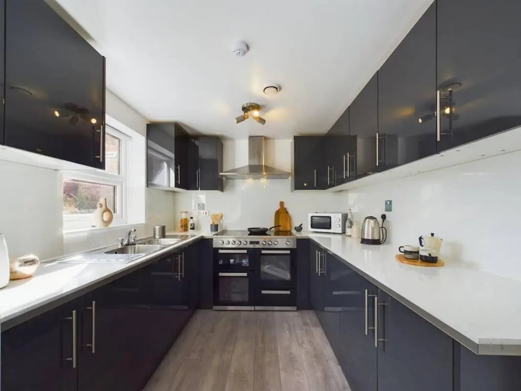 Modern U-shaped kitchen with dark cabinets and appliances kitchen at 5 Bedroom House at 2, Crofton Street in Manchester Student Accommodation