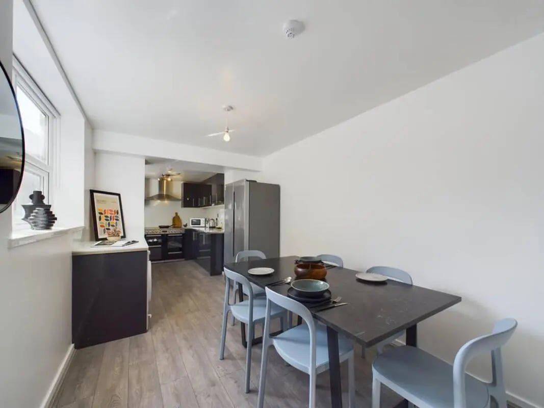 Dining table with chairs and kitchen area. at 5 Bedroom House at 2, Crofton Street in Manchester Student Accommodation