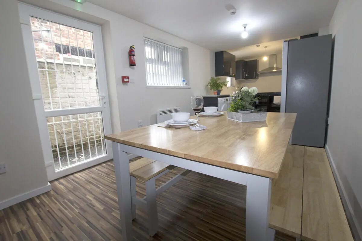 Table with settings kitchen area and exterior at 6 Bedroom House at 31, Deramore Street in Manchester Student Accommodation