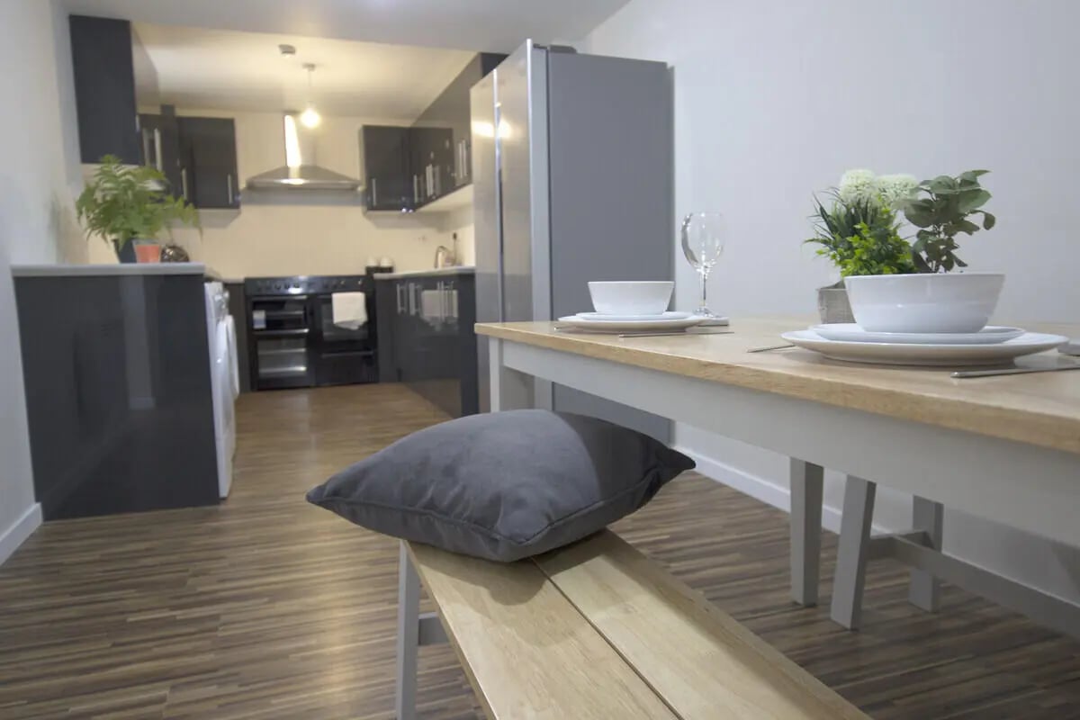Table with place settings and kitchen area kitchen at 6 Bedroom House at 31, Deramore Street in Manchester Student Accommodation