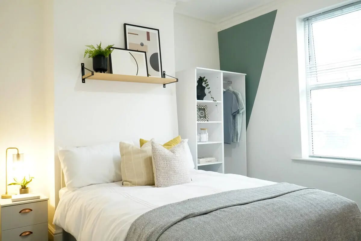 Bed with pillows wardrobe shelf art bedroom at 5 Bedroom House at 14, Driffield Street in Manchester Student Accommodation