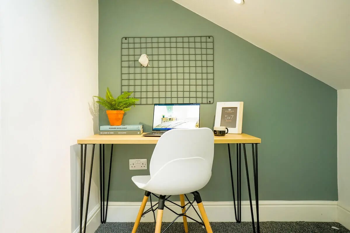 Desk with laptop plant frame and chair Study area at 5 Bedroom House at 19, Driffield Street in Manchester Student Accommodation