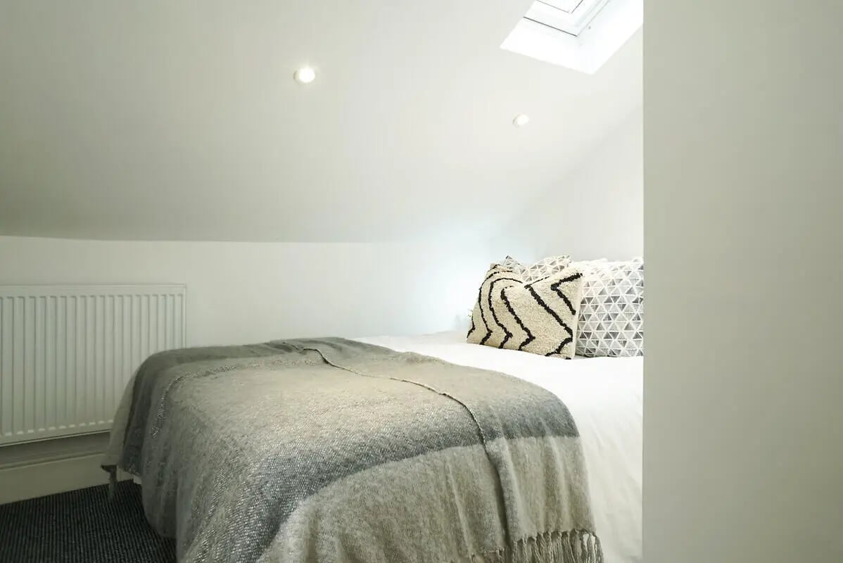 Bed with patterned pillows and grey throw bedroom at 5 Bedroom House at 19, Driffield Street in Manchester Student Accommodation