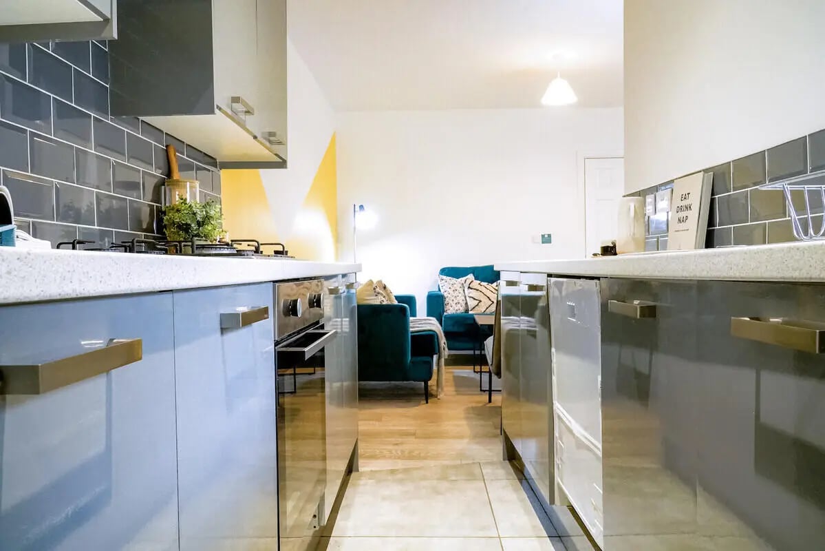 Modern kitchen with teal sofa living area kitchen at 6 Bedroom House at 28, Ruskin Avenue in Manchester Student Accommodation