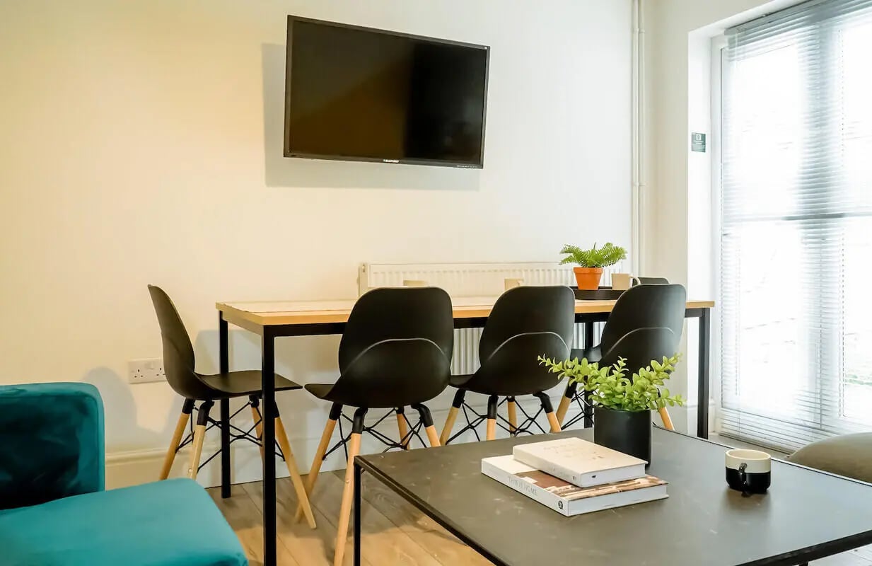 Wall mounted TV table four chairs living room at 6 Bedroom House at 28, Ruskin Avenue in Manchester Student Accommodation