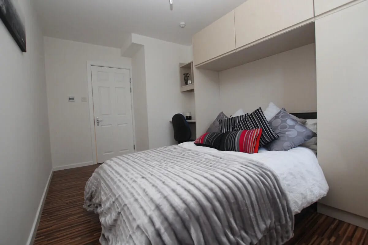 Bed with pillows and desk area bedroom at 6 Bedroom House at 49, Ruskin Avenue in Manchester Student Accommodation