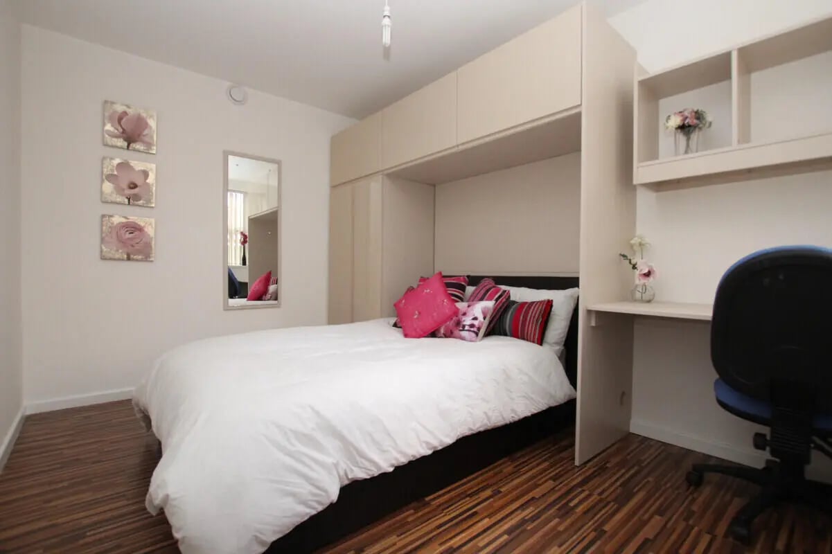 White bed with pink pillows desk and chair bedroom at 6 Bedroom House at 49, Ruskin Avenue in Manchester Student Accommodation
