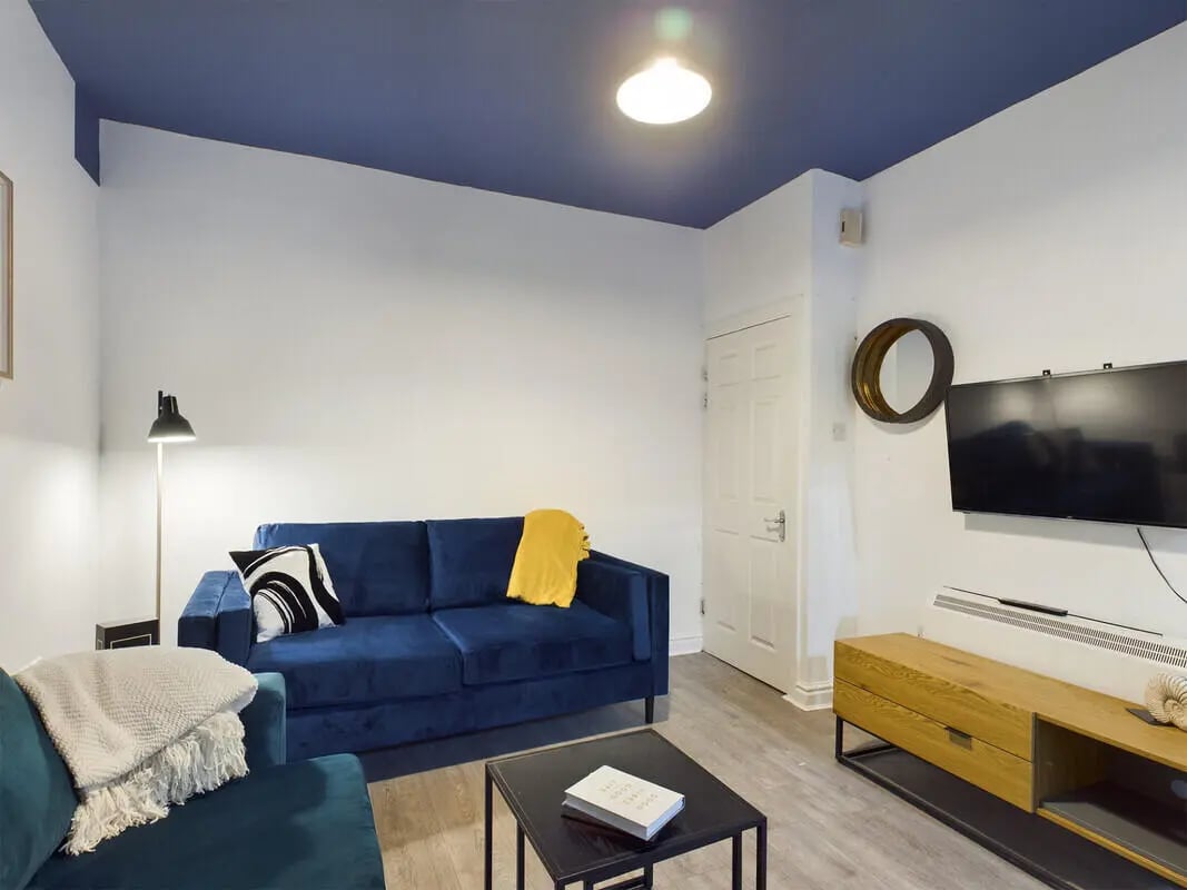 Blue sofa, floor lamp, television, living room at 6 Bedroom House at 10, Richmond Road in Lincoln Student Accommodation