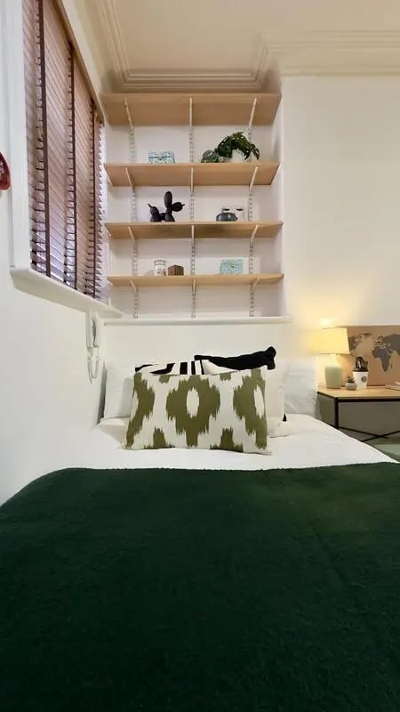 Bed with green blanket shelves and patterned pillows Bedroom at 6 Bedroom House at 12, Studios at, Richmond Road in Lincoln Student Accommodation