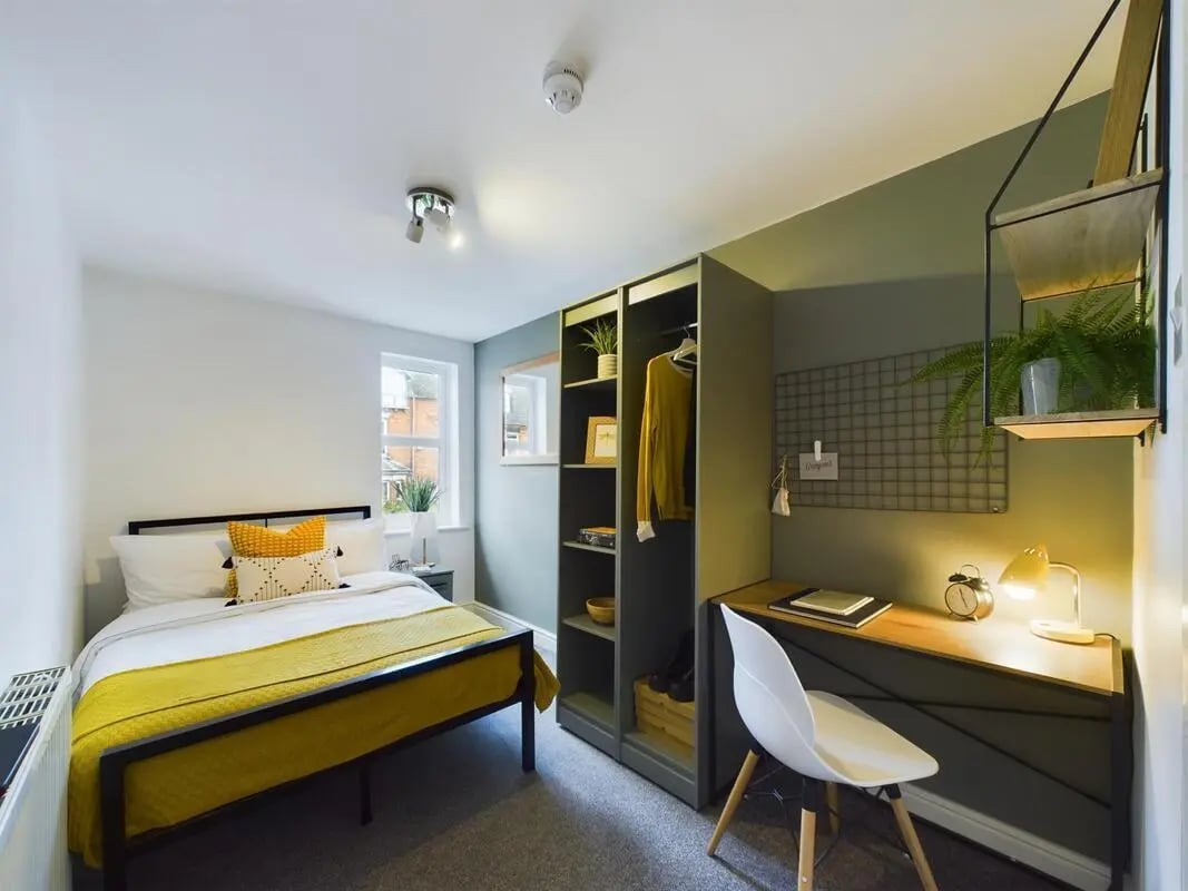Bed desk wardrobe with yellow bedding bedroom at 6 Bedroom House at 73, West Parade in Lincoln Student Accommodation