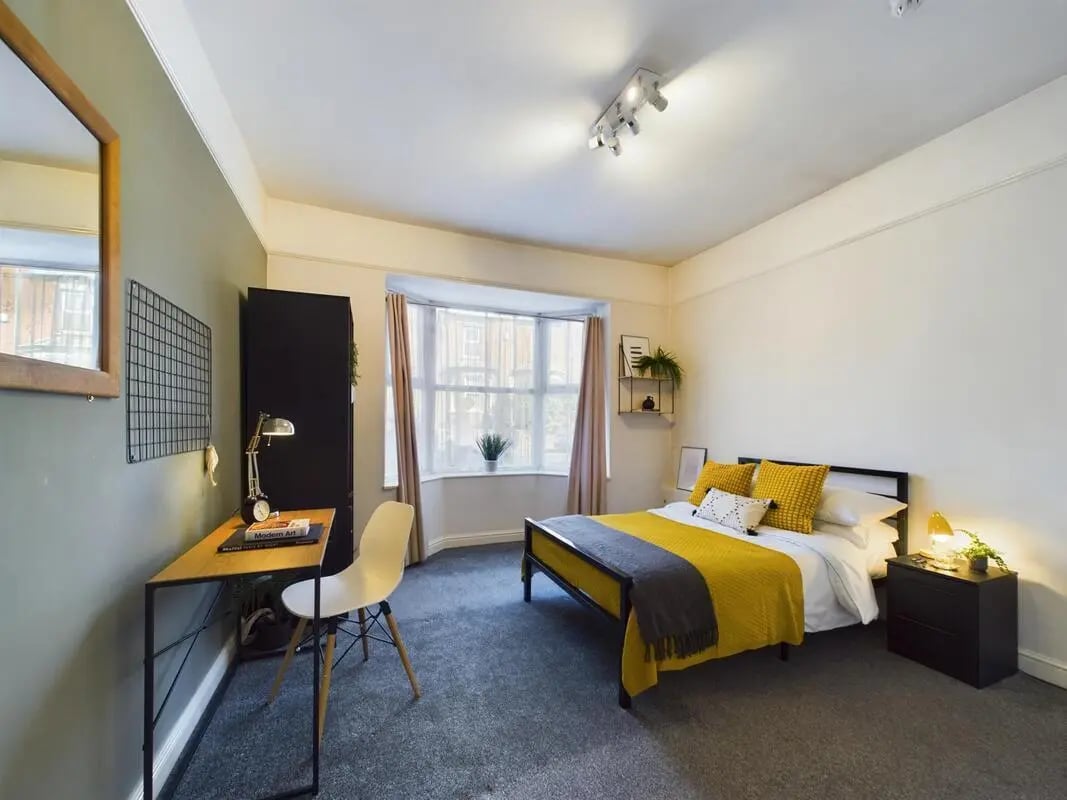 Bed desk wardrobe yellow bed linens bedroom at 6 Bedroom House at 73, West Parade in Lincoln Student Accommodation