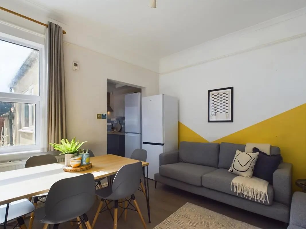 Dining table sofa fridge artwork living room at 6 Bedroom House at 73, West Parade in Lincoln Student Accommodation