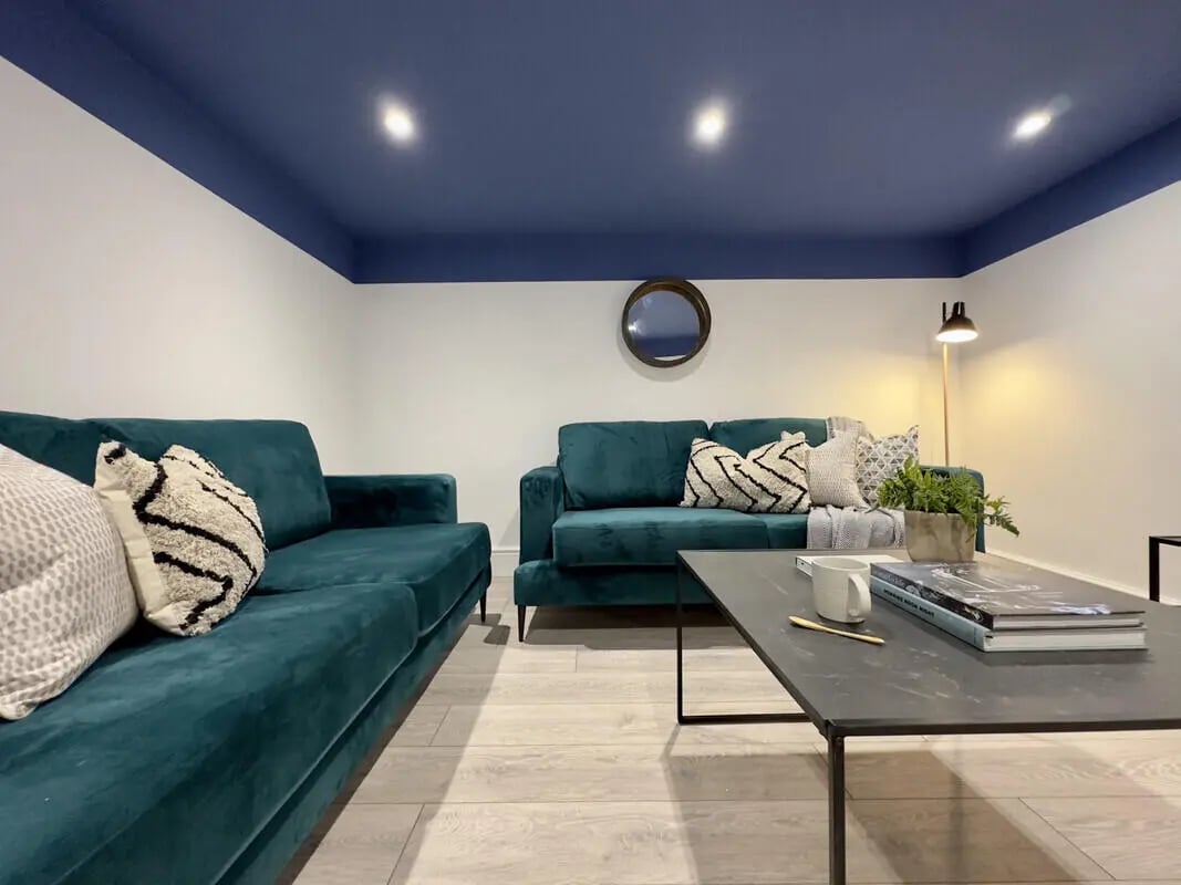 Two teal sofas coffee table and lamp living room at 6 Bedroom House at 43, Monks Road in Lincoln Student Accommodation