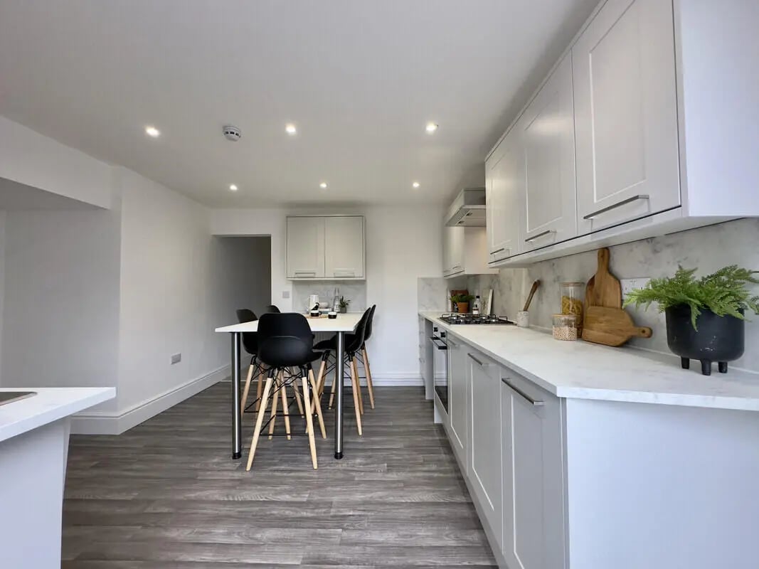 Modern white kitchen table chairs and cabinets kitchen at 6 Bedroom House at 43, Monks Road in Lincoln Student Accommodation
