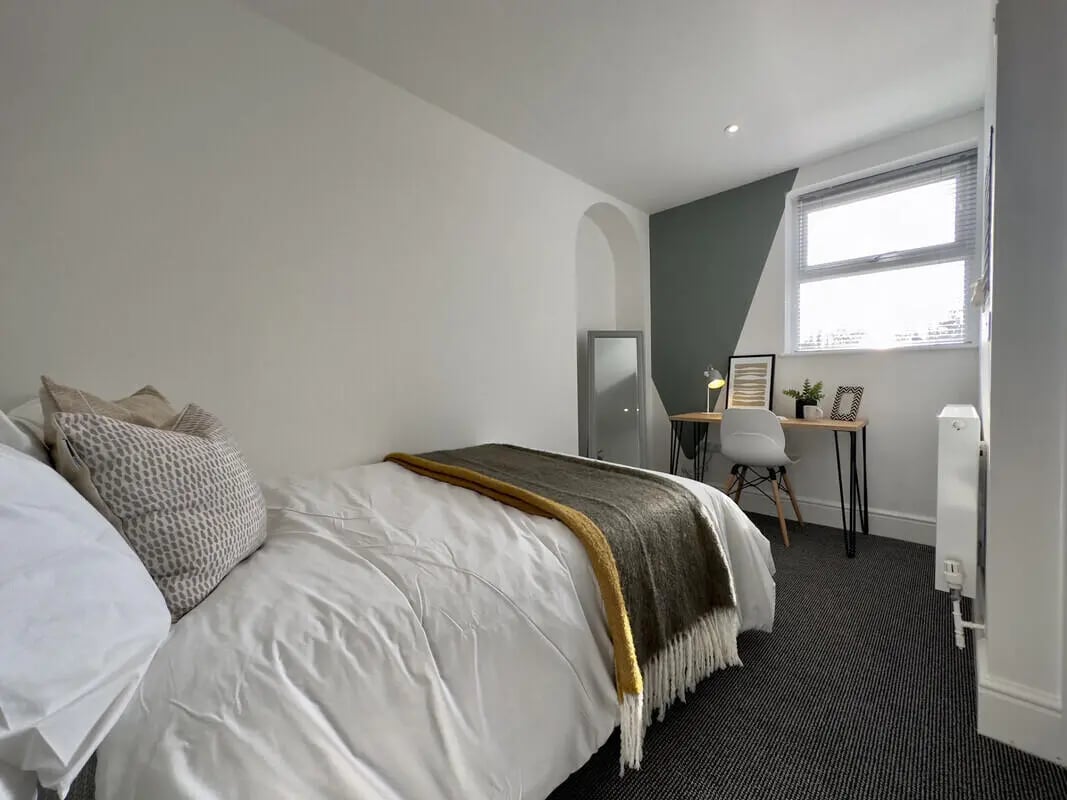 Bed with pillows desk lamp chair mirror bedroom at 6 Bedroom House at 43, Monks Road in Lincoln Student Accommodation