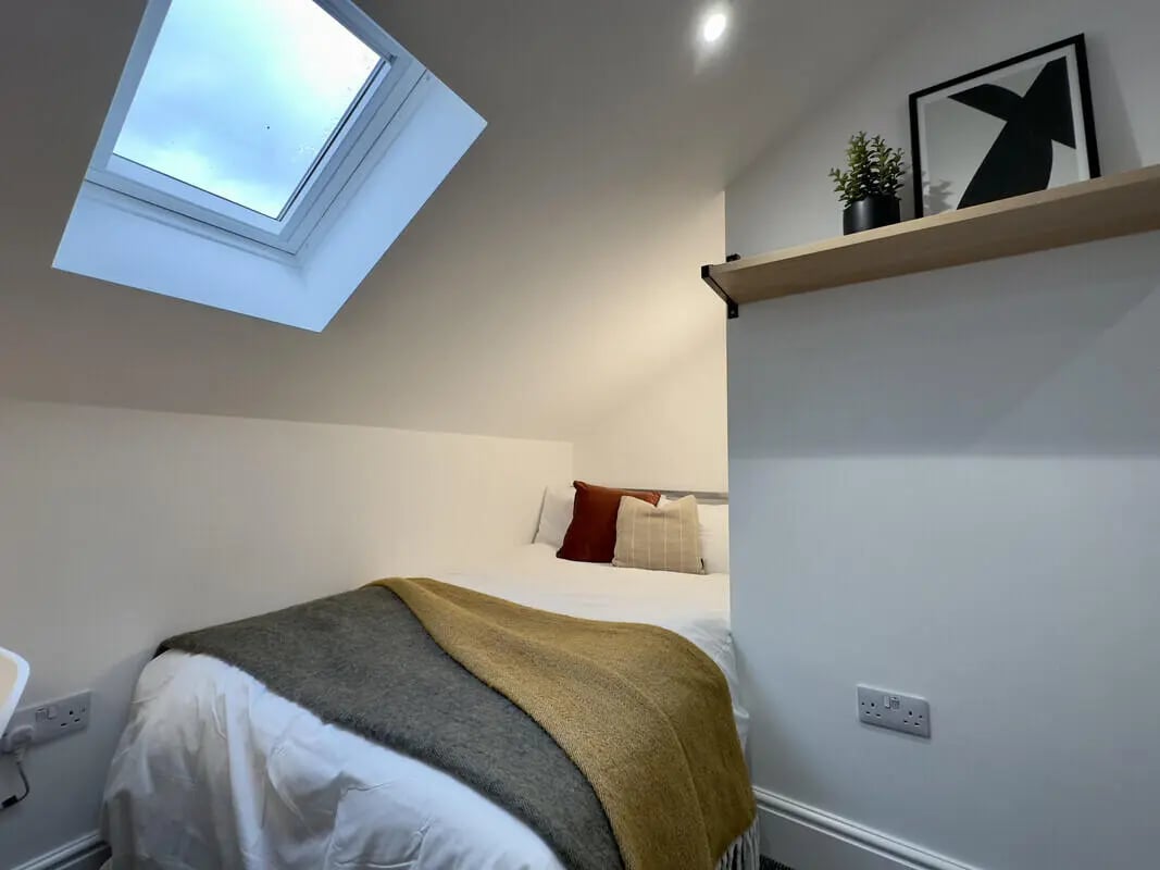 Bed with pillows and blankets skylight Bedroom at 6 Bedroom House at 43, Monks Road in Lincoln Student Accommodation