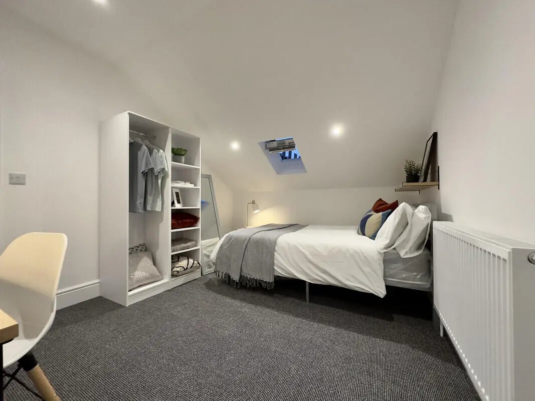 White wardrobe bed rug and chair bedroom at 6 Bedroom House at 45, Monks Road in Lincoln Student Accommodation