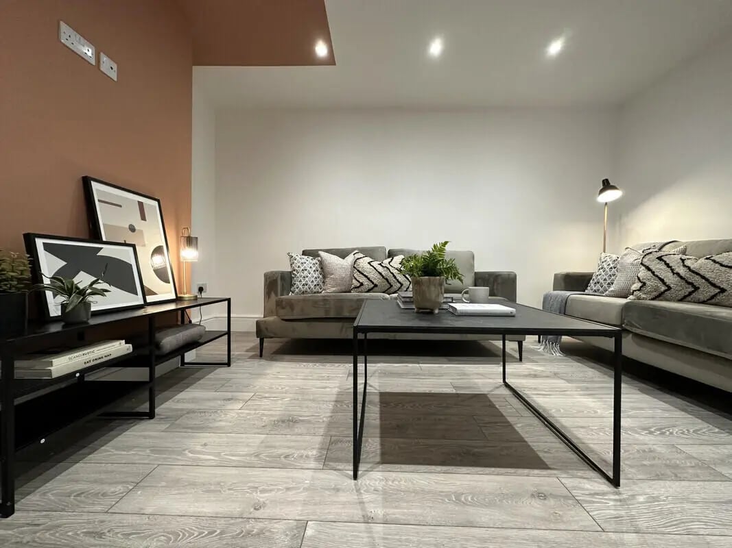 Gray sofas coffee table plants abstract art living room at 6 Bedroom House at 45, Monks Road in Lincoln Student Accommodation