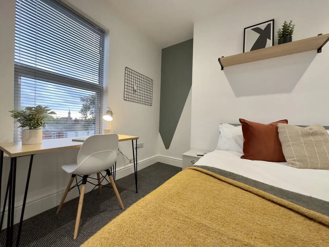 Desk chair plant lamp bed pillows blanket bedroom at 6 Bedroom House at 45, Monks Road in Lincoln Student Accommodation