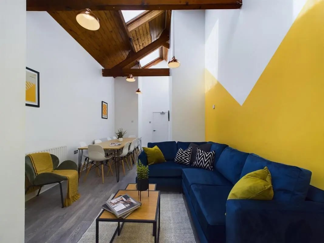 Blue sectional couch dining table and chairs living room at 9 Bedroom House at 19A, Bower Road in Sheffield Student Accommodation
