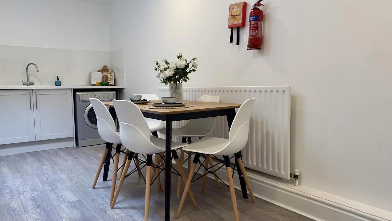 Table chairs vase fire extinguisher kitchen area at 6 Bedroom House at 19C, Bower Road in Sheffield Student Accommodation
