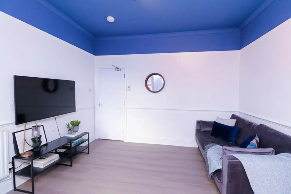 Television couch and blue ceiling living room at 7 Bedroom House at 106, Yarborough Road in Lincoln Student Accommodation