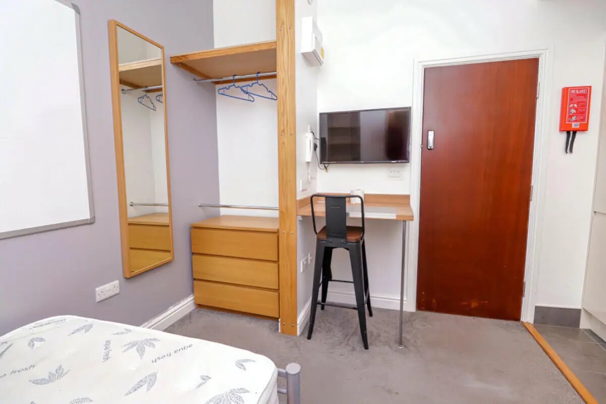 Wardrobe drawers mirror desk TV and stool bedroom at 7 Bedroom House at 106, Yarborough Road in Lincoln Student Accommodation