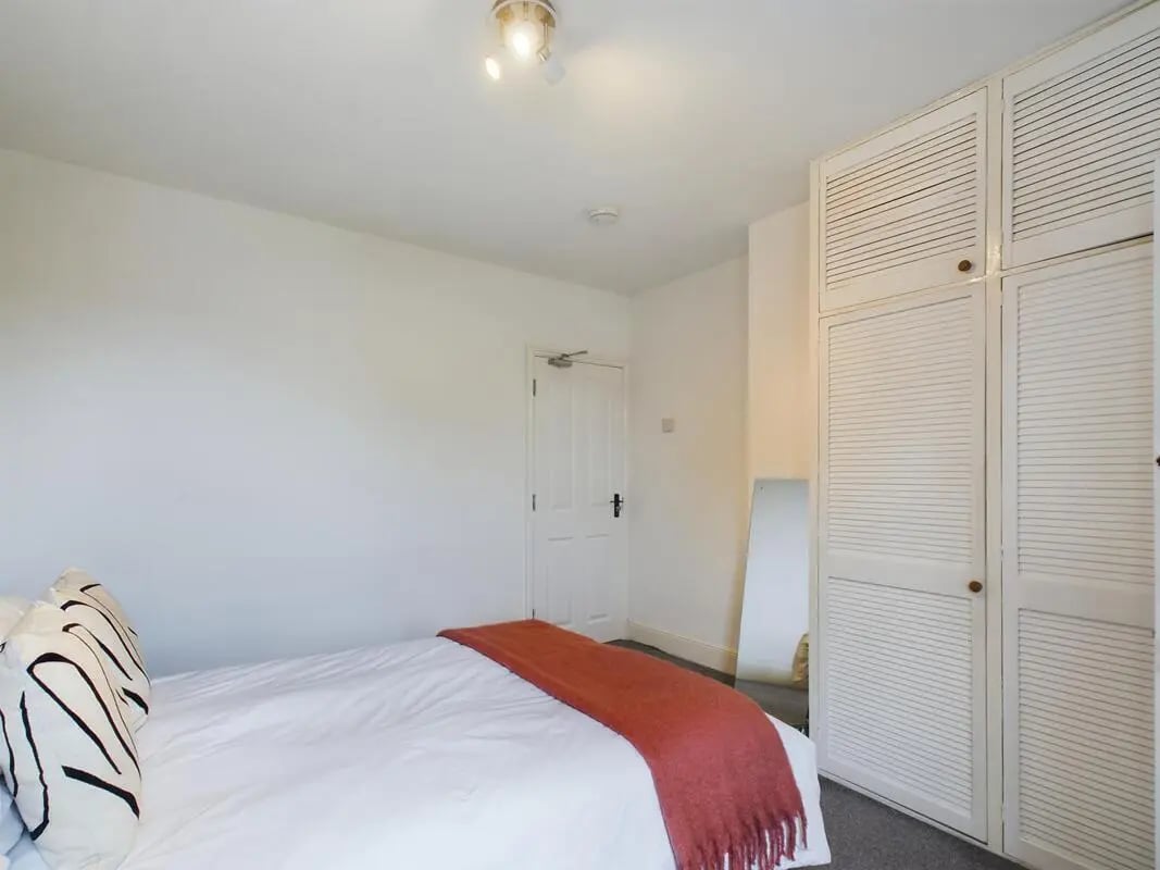 Bed with orange throw and large wardrobe Bedroom at 4 Bedroom House at 11, Charles Street West in Lincoln Student Accommodation
