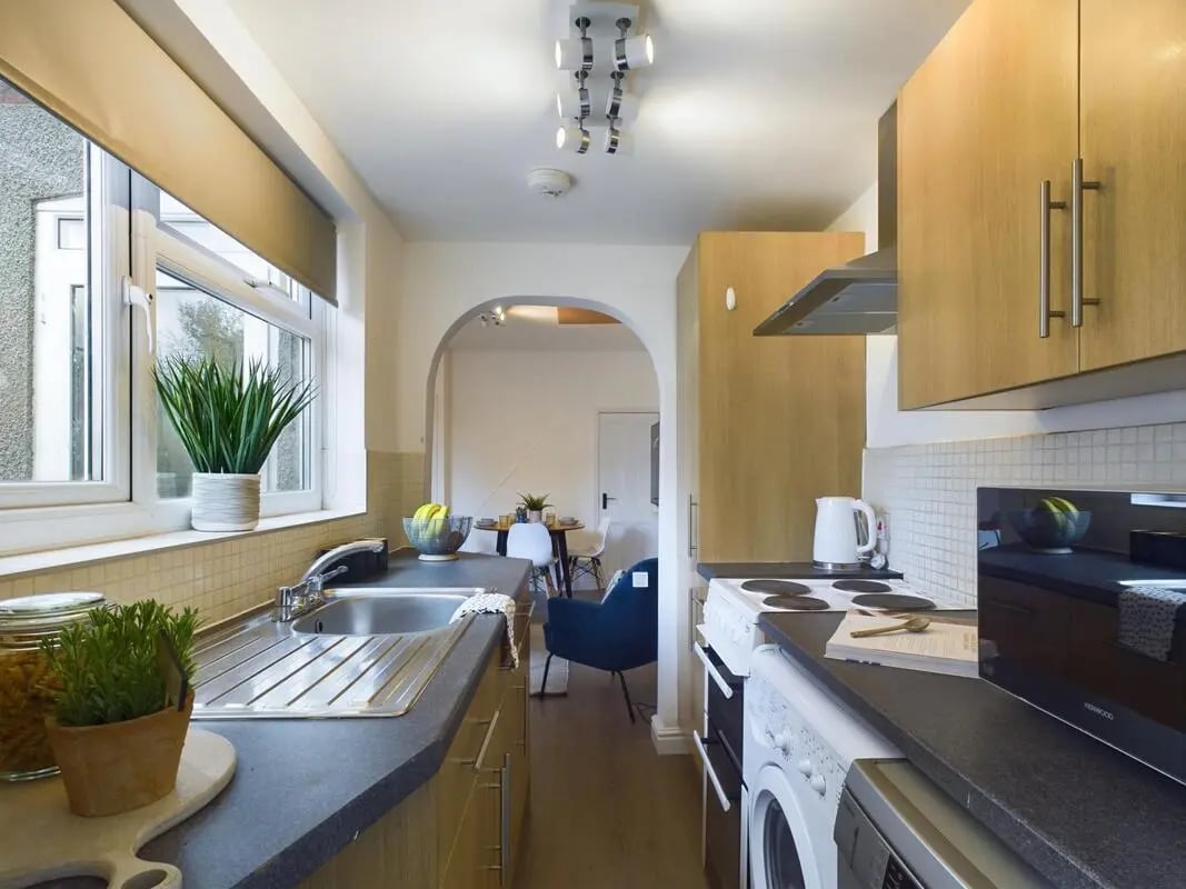 Sink plants cabinets microwave washing machine kitchen at 4 Bedroom House at 11, Charles Street West in Lincoln Student Accommodation
