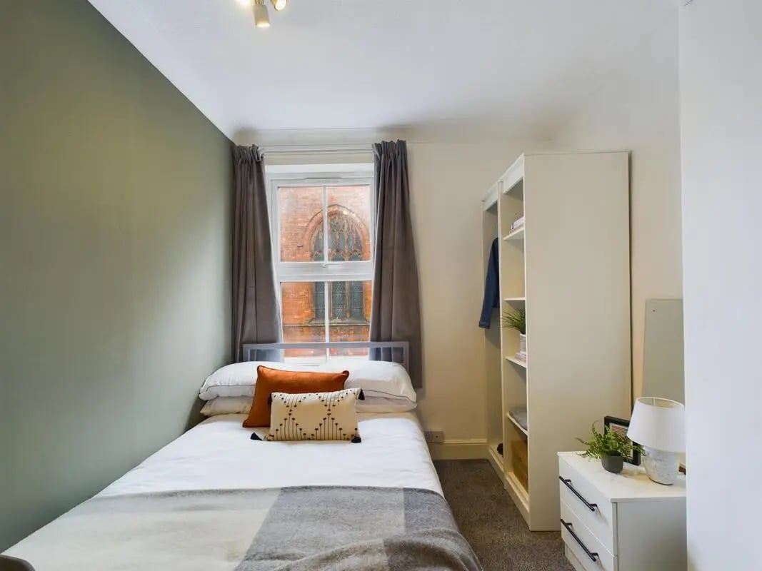 Bed with pillows white wardrobe and bedside table bedroom at 4 Bedroom House at 11, Charles Street West in Lincoln Student Accommodation