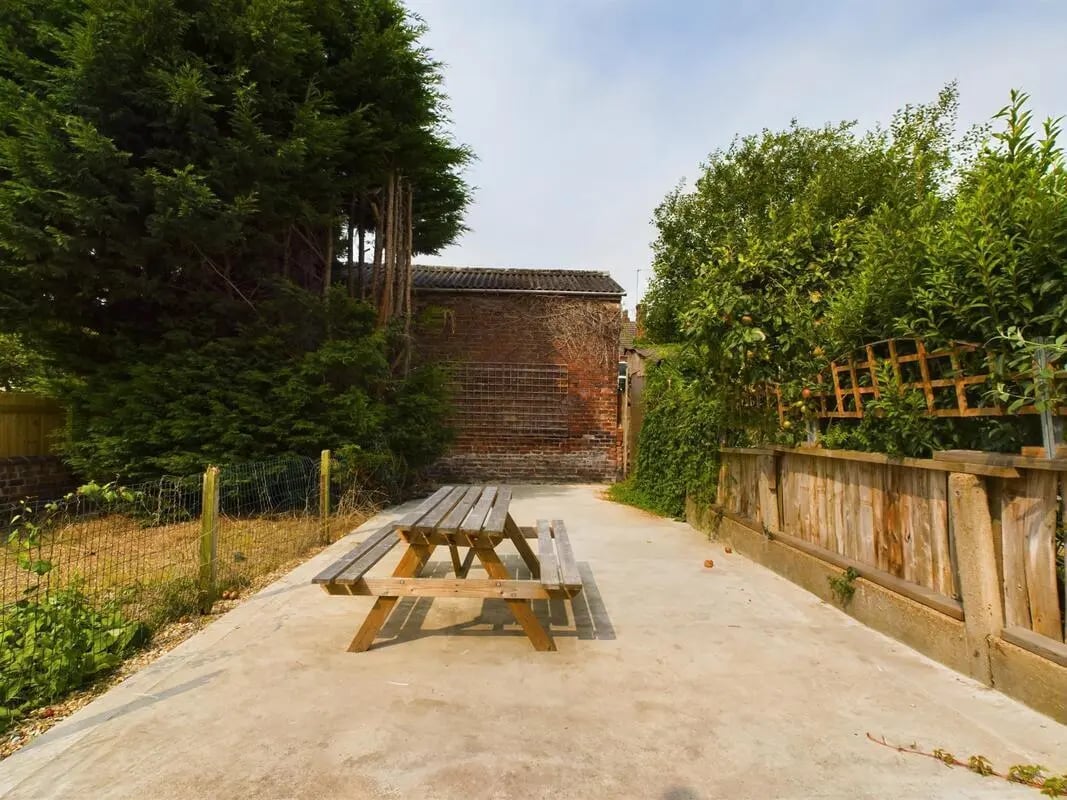 Wooden picnic table in a concrete yard exterior at 4 Bedroom House at 11, Charles Street West in Lincoln Student Accommodation