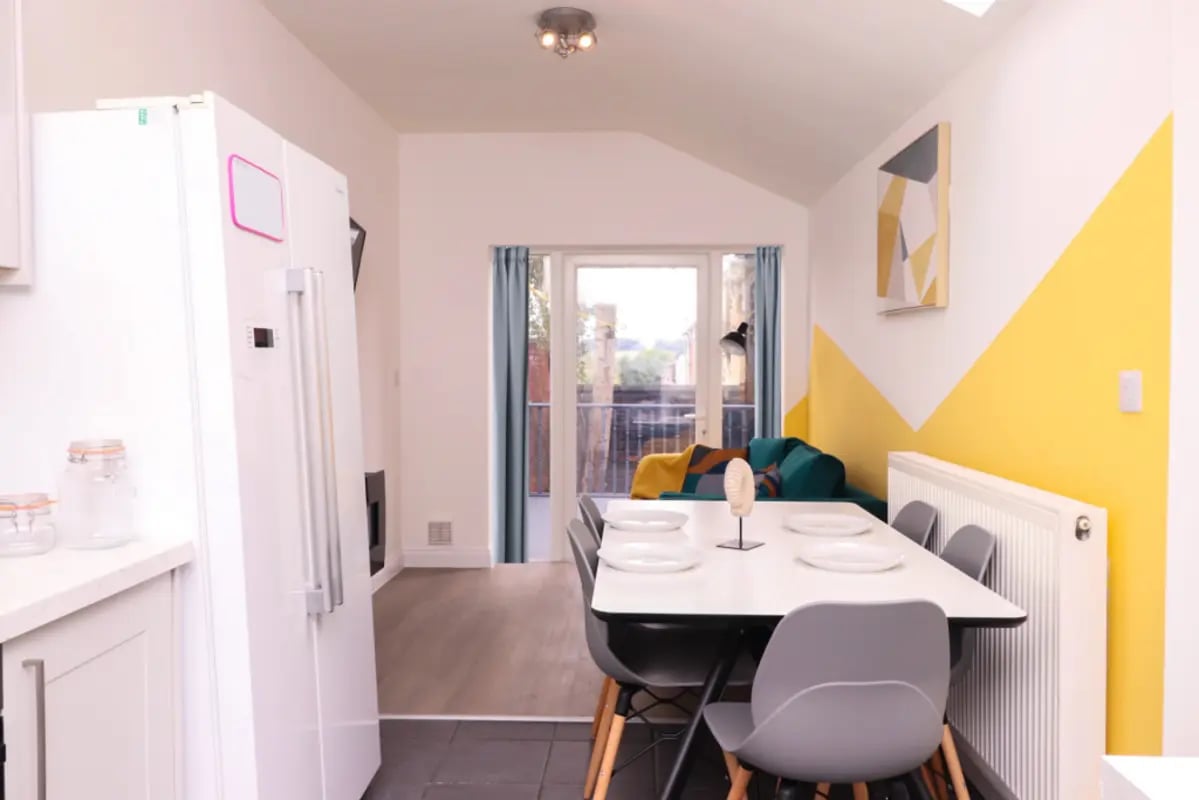White refrigerator dining table chairs living room exterior at 5 Bedroom House at 99, Monks Road in Lincoln Student Accommodation