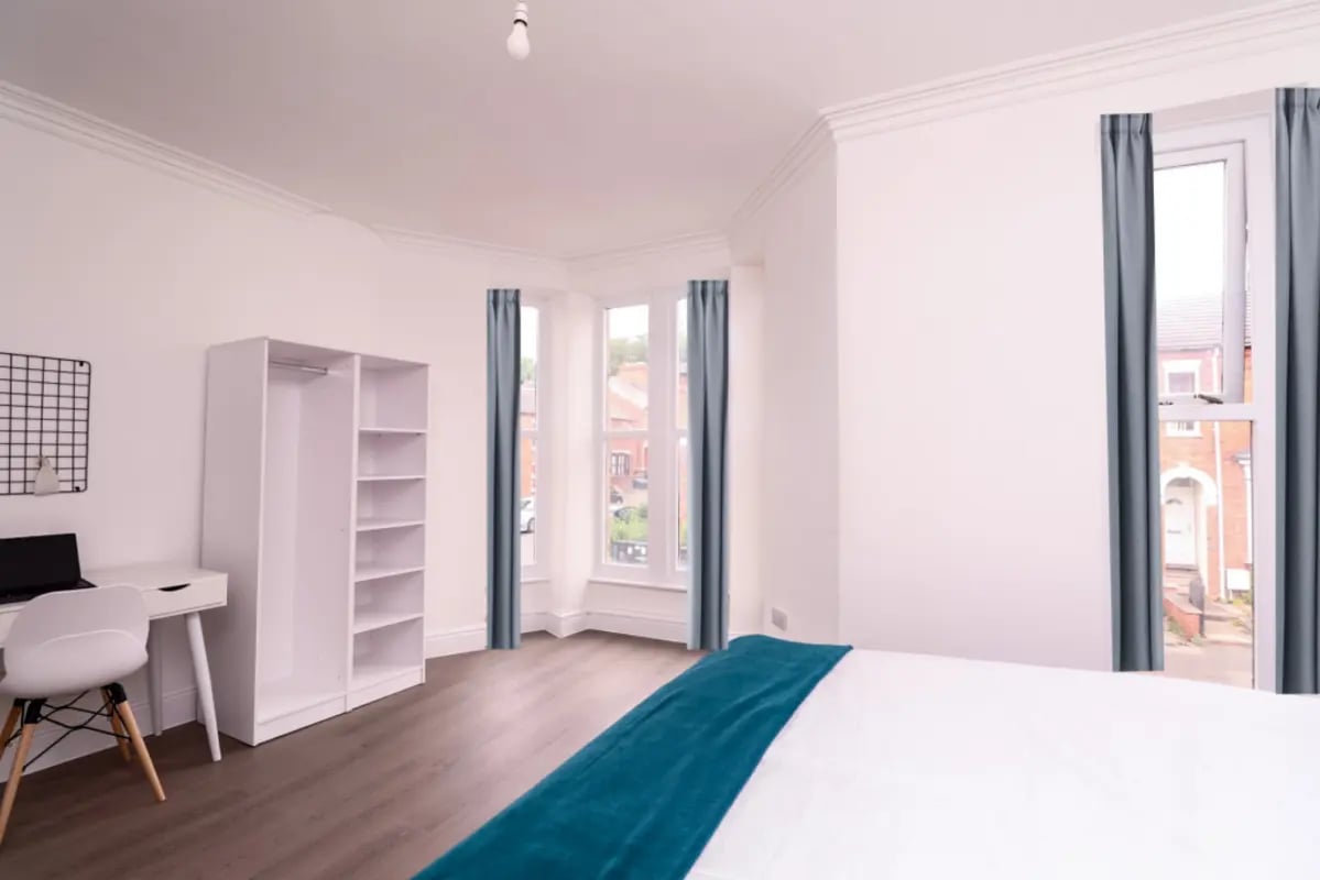 White wardrobe desk chair and laptop bedroom at 5 Bedroom House at 99, Monks Road in Lincoln Student Accommodation