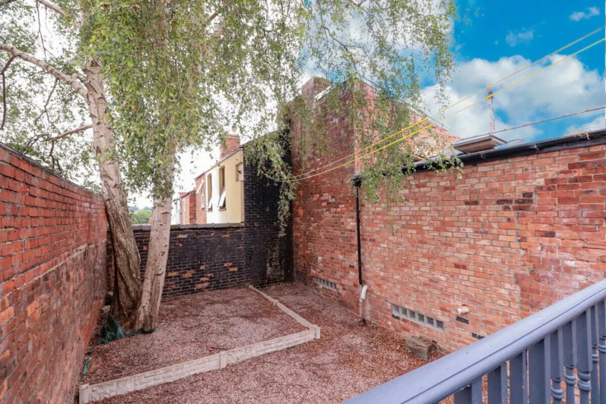 Brick courtyard with trees and railing exterior at 5 Bedroom House at 99, Monks Road in Lincoln Student Accommodation
