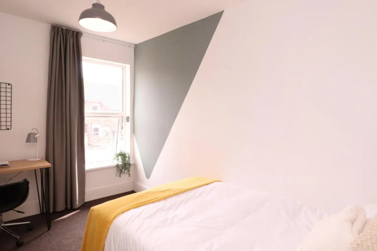 Bed with yellow throw desk chair and lamp bedroom at 5 Bedroom House at 43, Thesiger Street in Lincoln Student Accommodation