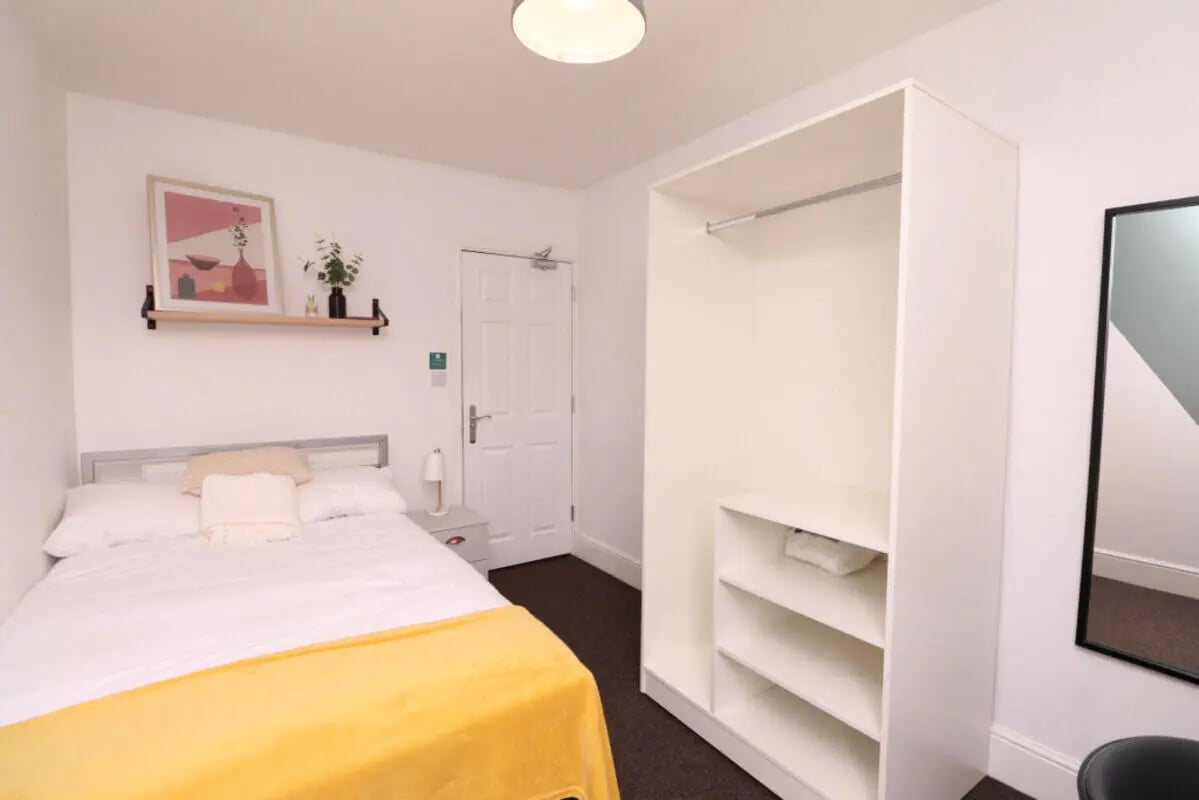 Bed with yellow blanket and wardrobe bedroom at 5 Bedroom House at 43, Thesiger Street in Lincoln Student Accommodation