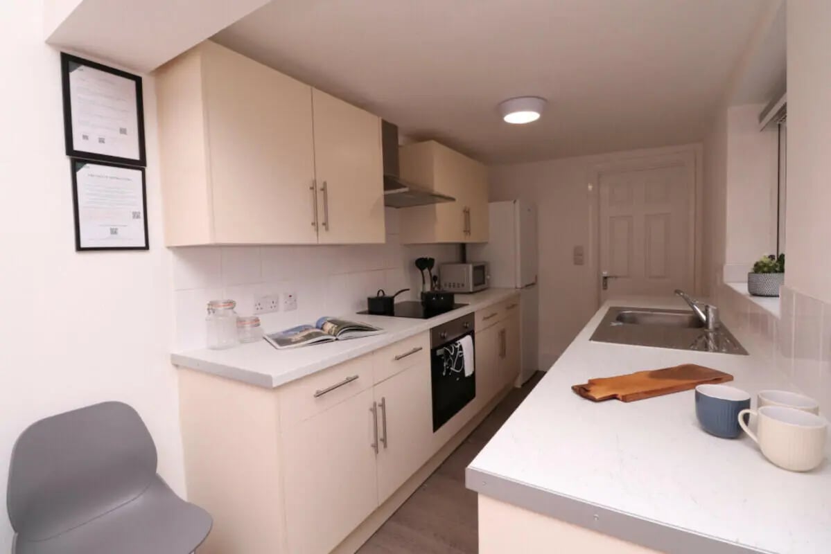 Cream cabinets sink stove and chairs kitchen at 5 Bedroom House at 43, Thesiger Street in Lincoln Student Accommodation