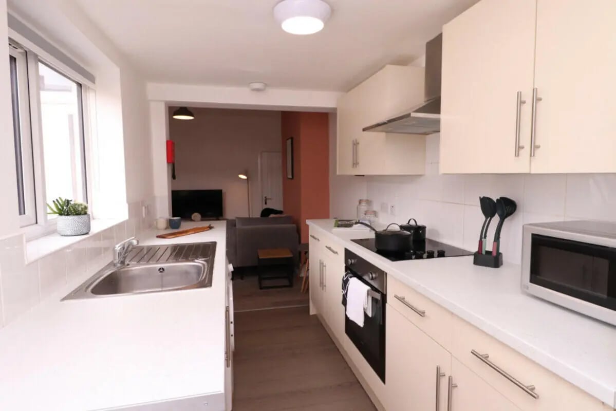 Sink stove microwave and cabinets kitchen at 5 Bedroom House at 43, Thesiger Street in Lincoln Student Accommodation