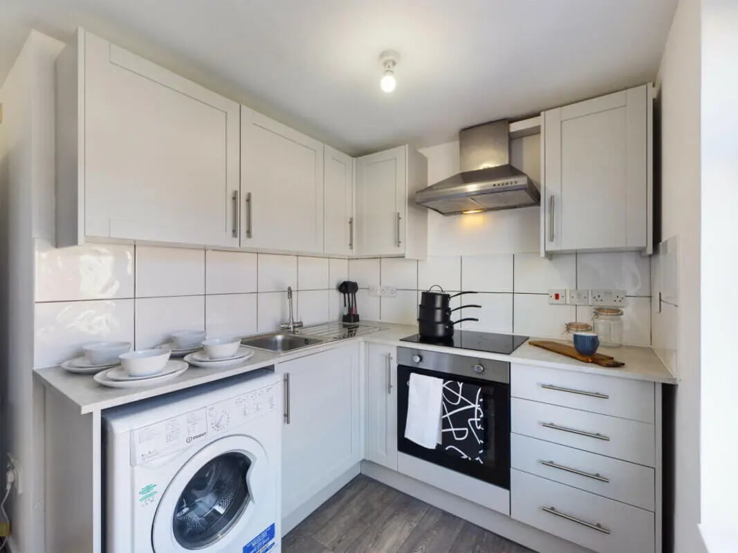 White cabinets washing machine oven stovetop kitchen at 2 Bedroom House at Flat 2 30, Haydn Avenue in Manchester Student Accommodation